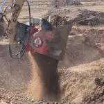 A man is digging in the dirt with an excavator.