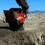 A large machine is digging in the dirt.