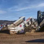 A large machine is parked in the dirt.