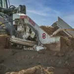 A large machine is digging in the dirt.