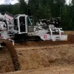 A large machine is on the ground in a field.