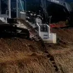 A large machine is on the ground near some dirt.
