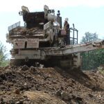 A large machine is on top of some dirt.