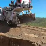 A large machine is on the ground near some dirt.