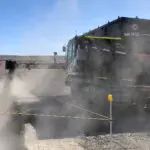 A train is coming down the tracks in the desert.