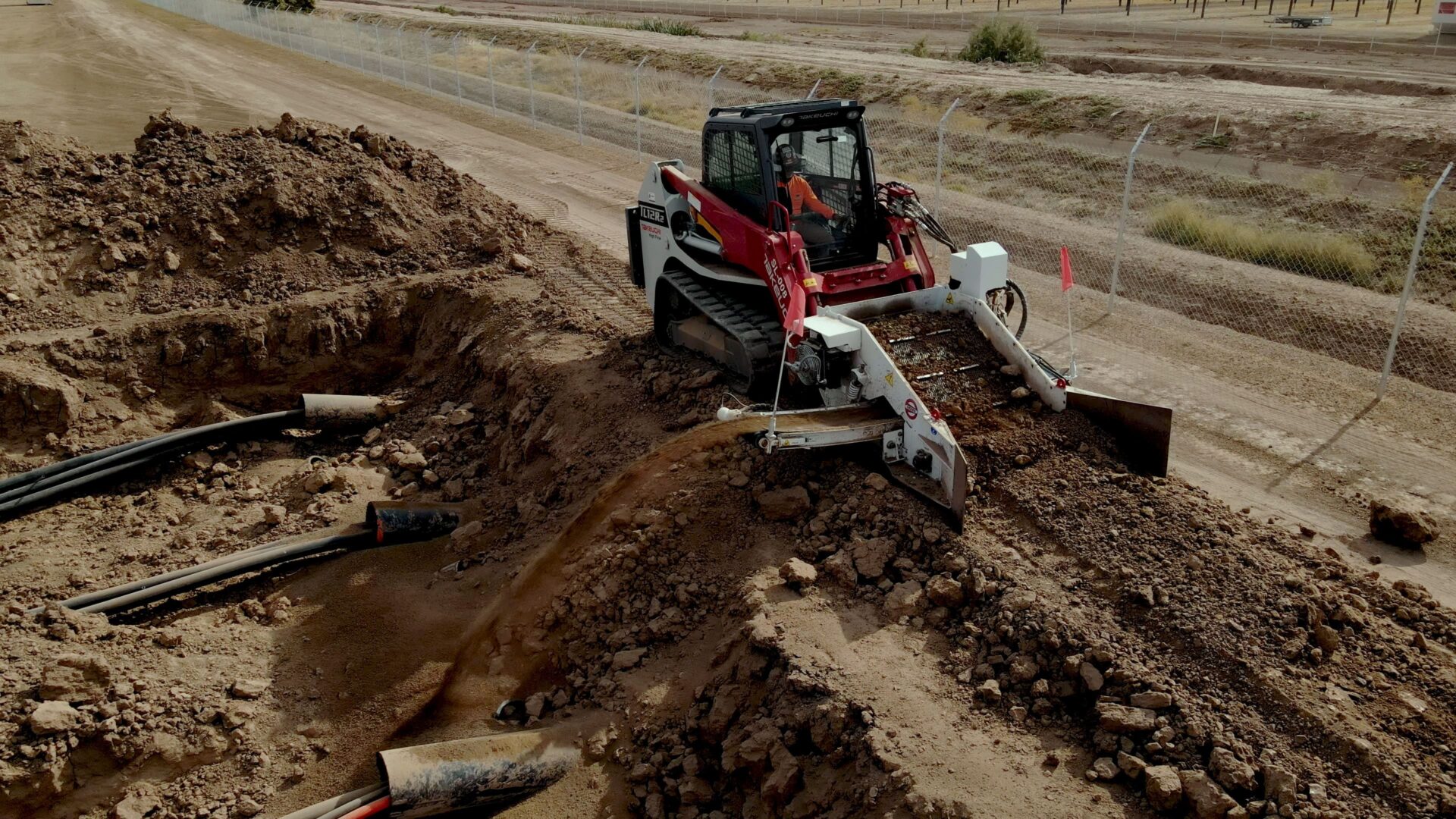 A red and white tractor is on the dirt