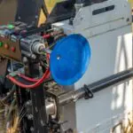 A blue disc is attached to the side of an industrial machine.