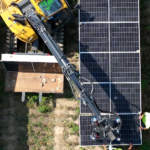 A man on a crane is working on solar panels.